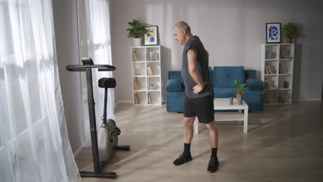 gymnastics-for-prevention-of-osteochondrosis-middle-aged-man-is-training-alone-at-sunday-morning-warming-muscles-and-joints